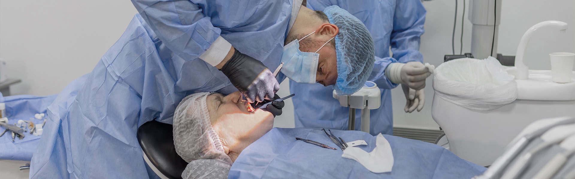 Oral Surgery Dentist Operating On Patient